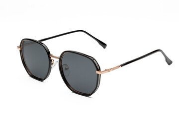 Stylish and fashionable black sunglasses with gold details on a white background