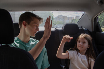 Siblings share a joyful moment in the backseat of a car