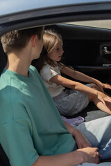 Two children having a conversation in the backseat of a car