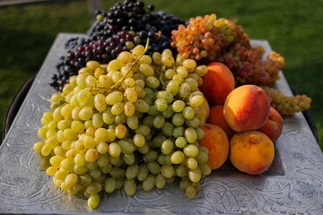 Fresh grapes and peaches on a decorative tray