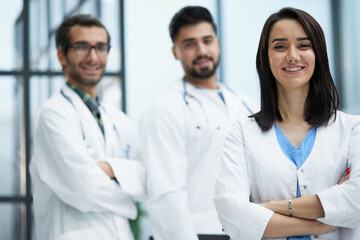 Fototapeta premium Attractive female doctor in front of medical stuff in hospital
