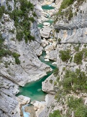 Un canyon spectaculaire dans les Alpes françaises, avec des parois rocheuses abruptes et de l'eau bleu clair qui serpente au fond.