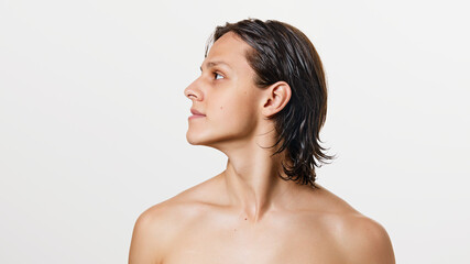 Portrait of young attractive brunette man with wet hair posing shirtless against white studio background. Concept of natural beauty, fashion, cosmetic product, male health. Ad