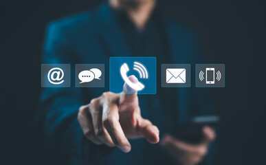 Customer Service Call Center, Contact US, Care Support Hotline, Hand touches glowing digital phone icon among various communication symbols, representing customer service and multiple contact methods.