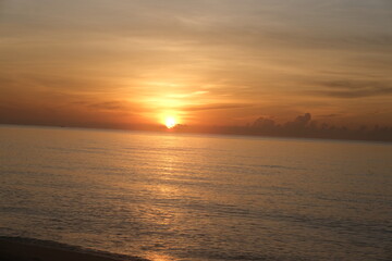 The sun rises at the sea in the morning.
