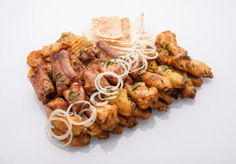 Delicious platter of grilled chicken pieces and crispy flatbreads served with sliced onions, showcasing a vibrant culinary experience