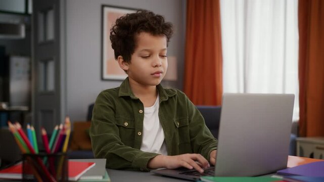 African American son male kid child boy pupil student schoolboy study at home typing browsing laptop computer studying distant learning homework e-learning play game online education internet using