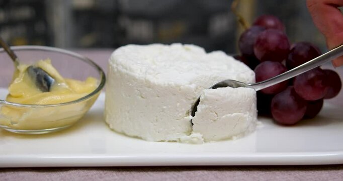 Fresh homemade dairy ricotta cheese, close-up opening white net bag. fresh ricotta cheese with linden white light honey