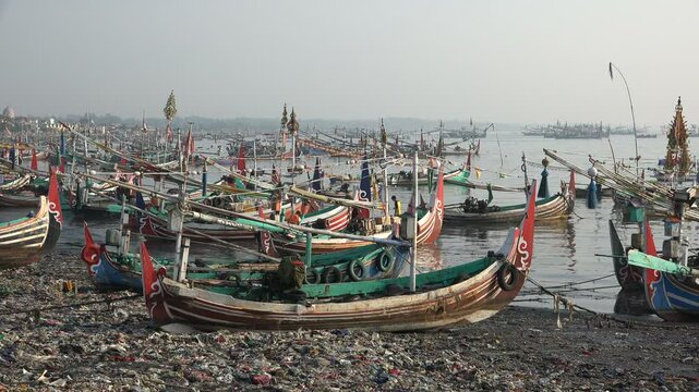 Traditional fishing boats on a heavily polluted beach in East Java, Indonesia
