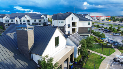 Close-up metal roofing of new apartment complex in fast growing area near Pflugerville northeast of downtown Austin, Texas, modern multistory building rental community, housing market, aerial © trongnguyen