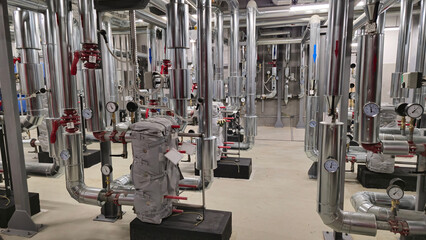 Fototapeta premium Heat exchange station with water pipes and heating elements. Sensors and pumping station under the building to ensure water supply