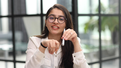 Photo of beautiful woman looking at camera while sitting at office