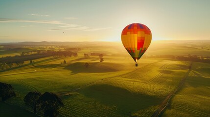 Obraz premium Urban skyline at sunset with silhouettes of high-rise buildings against a warm, glowing sky and lush rooftop garden in the foreground.