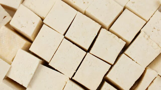 Raw organic vegetarian tofu cubes circle totation close up top view