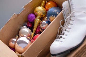 vintage wooden drawer with white ice skates and cardboard box filled with nostalgic colorful...