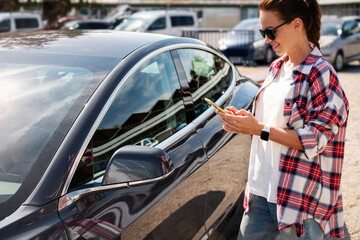 A female driver unlocks a car-sharing vehicle using her smartphone.