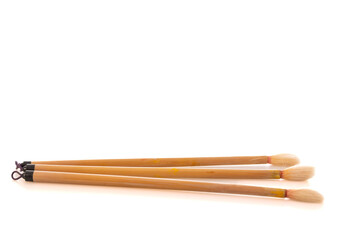 Three artistic paintbrushes arranged on a bright surface during daylight hours, representing creativity in a studio environment
