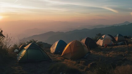 Tents are perched on a mountain ridge at sunset, with breathtaking views of the surrounding valley and sky painted in hues of orange and purple.