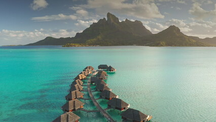 Bora Bora exotic travel vacation getaway, romantic honeymoon tourist destination. Sunset over luxurious tropical paradise resort, overwater bungalows in turquoise lagoon, mount otemanu in background
