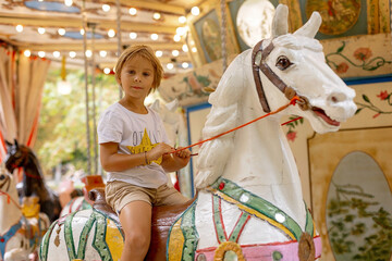 Child, going on Merry Go Round, kids play on carousel in the summer