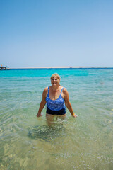 Woman relaxing on the beach in the sea. Selective focus.