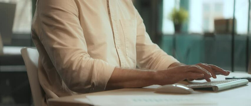 View on hands man using desktop computer typing on keyboard in office. Camera moving around. 360 degrees