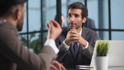 Focused stylish millennial businessman consulting expert at the table