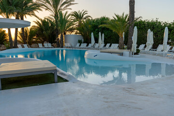 Relaxing pool surrounded by greenery and a beautiful sunset.