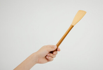 Hand holding a kitchen spatula on a white background
