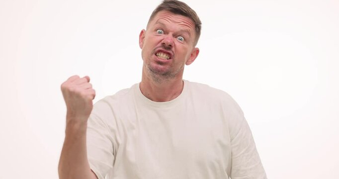 Man clenches fists demonstrating anger and aggression on white background. Voice of bearded guy gets louder and more aggressive slow motion