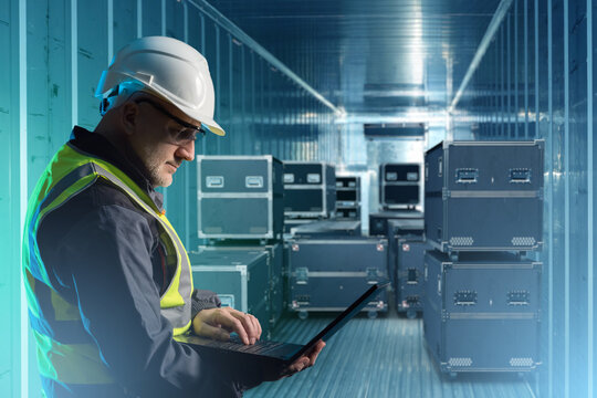 Loading ATA cases into sea container. Man port worker. Logistician with laptop in his hands. ATA boxes with filming equipment. Man controls dispatch of PLY cases. Delivery of musical apparatus