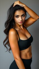 Fototapeta premium An athletic woman in a black sports bra and shorts, posing in a bright gym