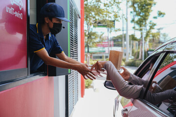 Man pick up food from drive-thru counters, drive-thru counters, and take-out outside of business...