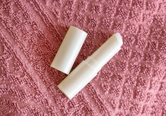 Opened lip balm stick on pink towels top view, lid mockup. Skincare beauty product