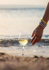 Woman with a glass of wine at the sea. Selective focus.