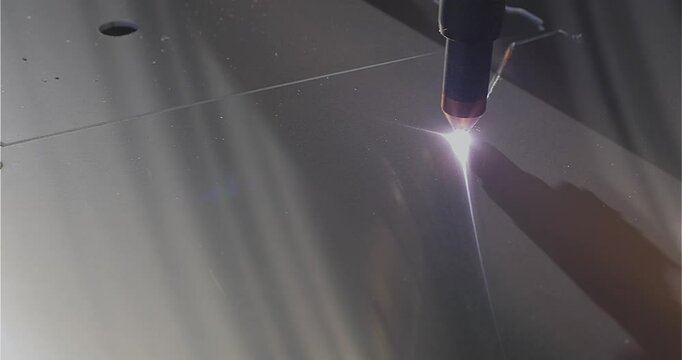 The process of cutting a metal part with a plasma cutter. The plasma cutter will cut the part. Plasma cutting Plasma cutter work at the factory.