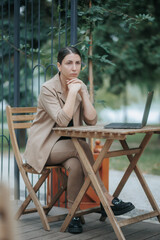 Contemplative Businesswoman in Suit Working Outside on a Laptop