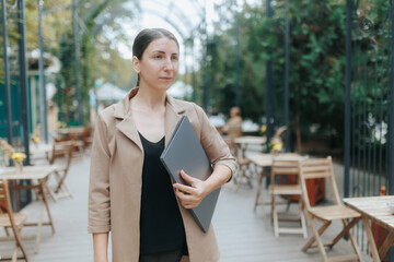 Modern Businesswoman Holding Laptop on Outdoor City Terrace