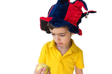 Boy in New Year hat is eating an apple. Christmas concept. Fruit time. Healthy eating concept