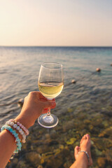 Woman with a glass of wine at the sea. Selective focus.