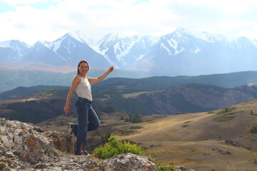 Hiker woman on top Aktash Altai mountains. Scenic view and snowy tops on background.