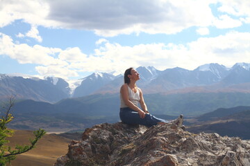 Hiker woman on top Aktash Altai mountains. Scenic view and snowy tops on background.