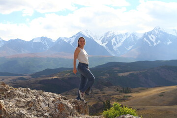 Fototapeta premium Hiker woman on top Aktash Altai mountains. Scenic view and snowy tops on background.