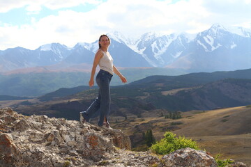 Obraz premium Hiker woman on top Aktash Altai mountains. Scenic view and snowy tops on background.