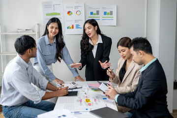 A group of people are sitting around a table with papers