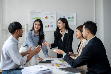 A group of people are sitting around a table, talking and laughing