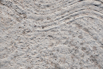 This high-resolution image captures the intricate details of weathered concrete, featuring a unique pattern of curved lines and subtle cracks. Ideal for design projects, website backgrounds, or creati