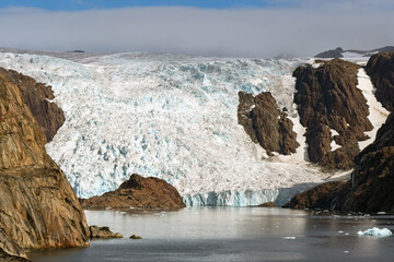 Scenic landscape view of a glacier at the water's edge of a fjord in Prince Christian Sound in...