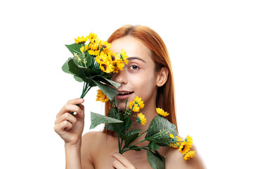 A vibrant portrait of a young redhead woman smiling subtly while holding a fresh bouquet of yellow...