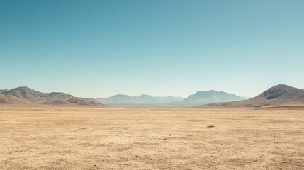 Fototapeta premium Dry desert landscape with distant mountains under a cloudless sky, room for text. No people, copy space